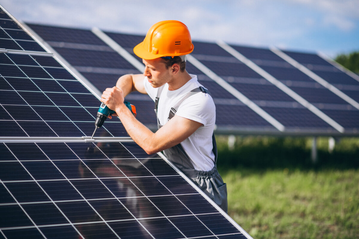 Pracownik montuje panele słoneczne - źródło energii słonecznej